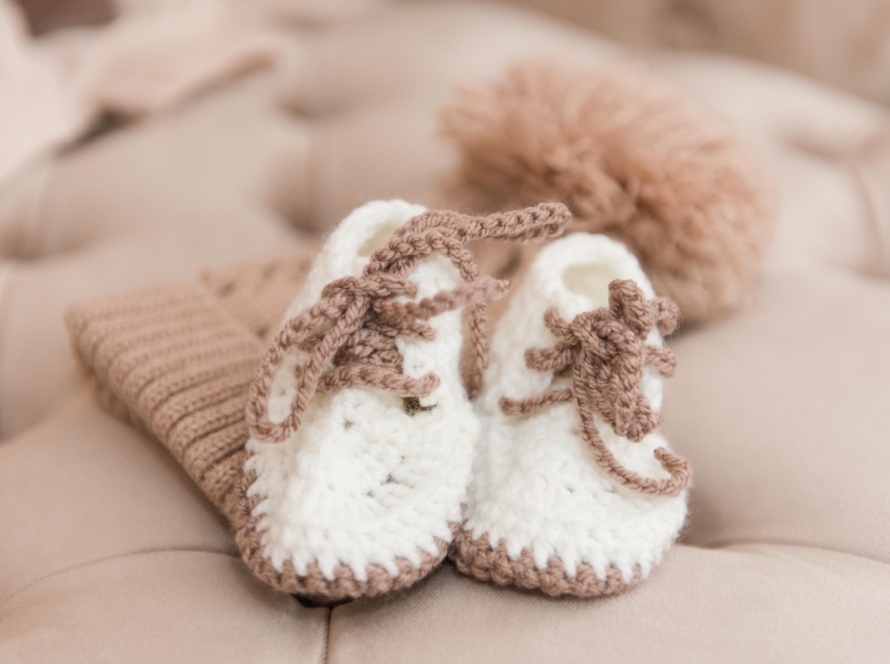 In the image we can see a pair of pumps and a wool cap in the hand of a woman