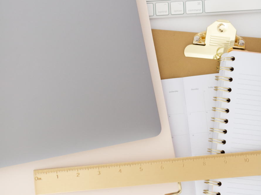 In the image, we can see an office work desk, laptop, notebook, ruler, agenda, etc.