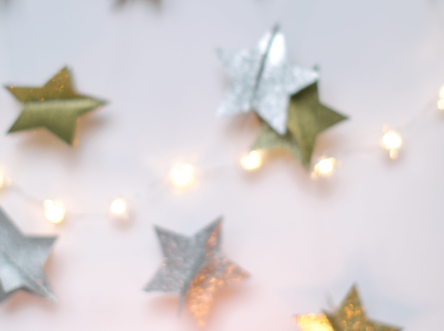 A number of gold and silver stars scattered across a table. At the bottom, there are 8 matches lit.