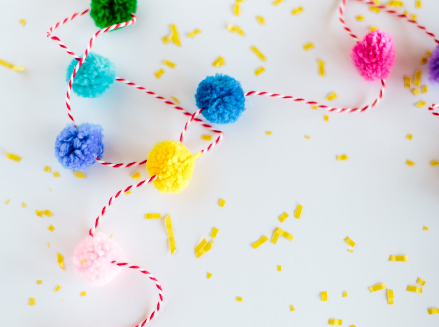 In the image we can see many cotton pompoms of different colors on a white background