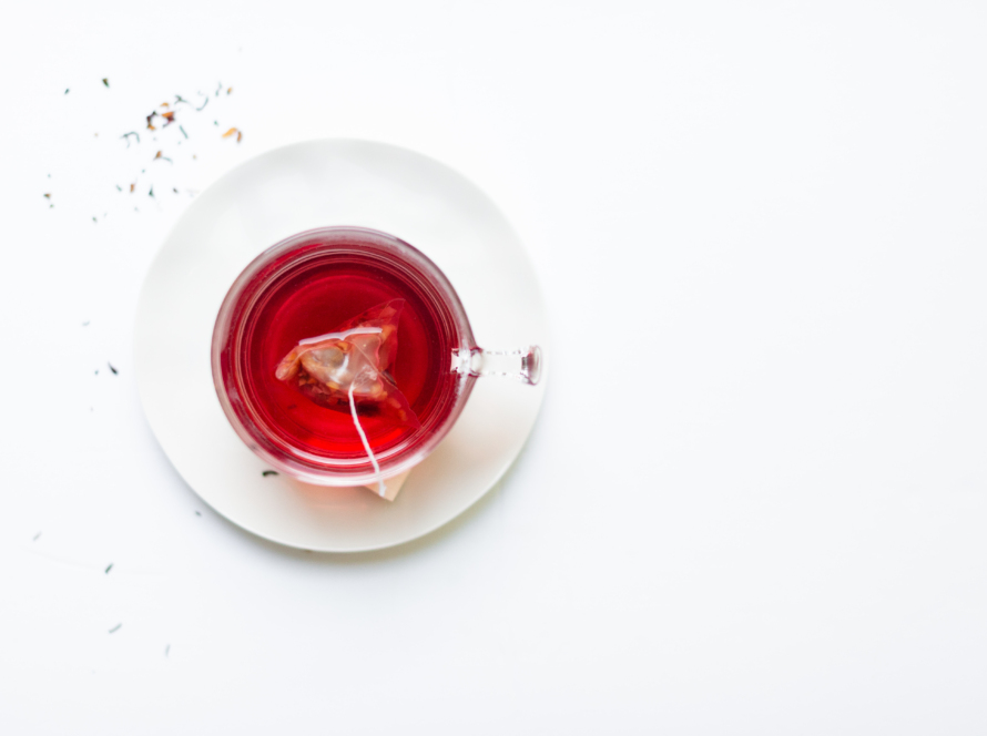 In the image, we can see a cup of red tea from above.