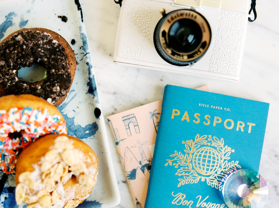 81 / 5.000 In the image, we can see a passport, a map, a camera and donuts.