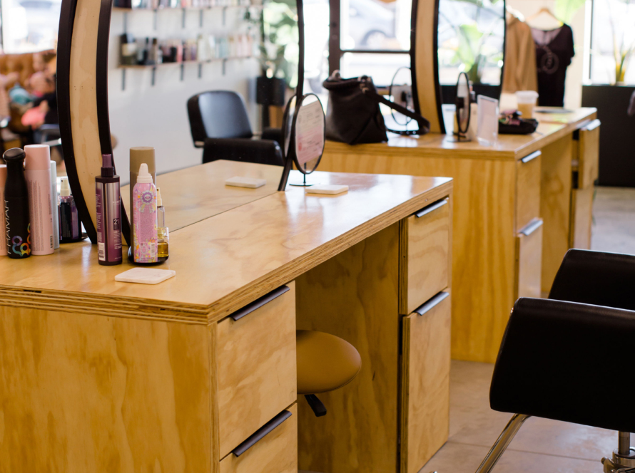 In the image, we can see makeup desks in perspective, each with an oval mirror.