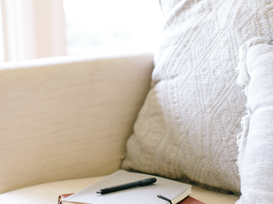 In a white armchair with pillows of the same color, we can observe a scorer and a pen by resting.