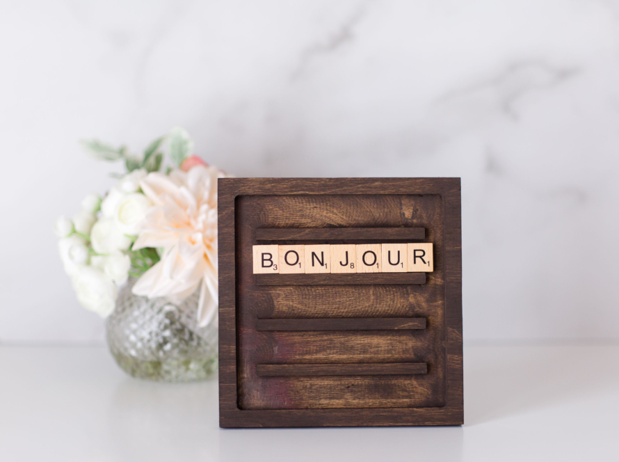 In a warm environment, we see a vase and in the foreground a sign with the legend Bon Jour