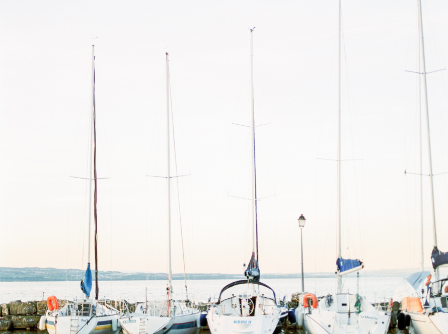 In the image, we can see many sailboats at a dock.
