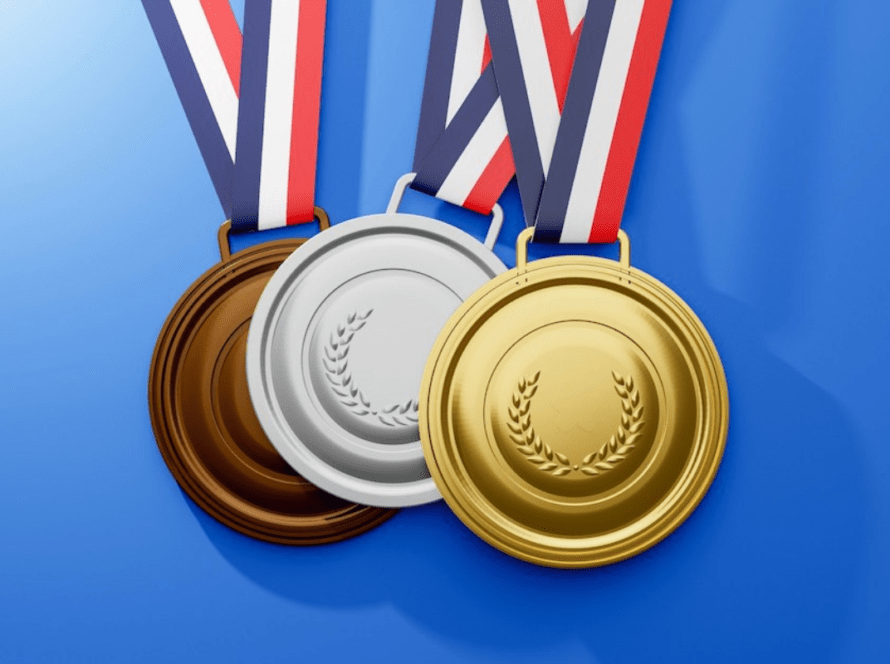 On a blue background -- are shown 3 medals hanging: bronze, silver, and gold. The ribbons holding each are red, white, and blue.